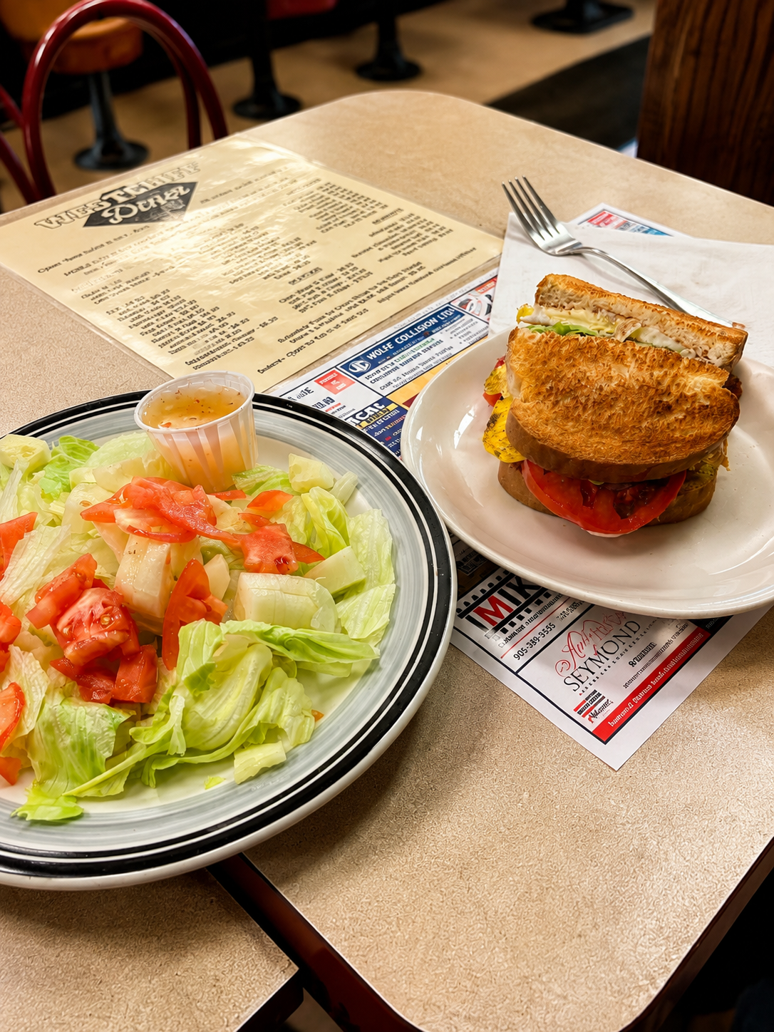Grilled club sandwich with a side salad