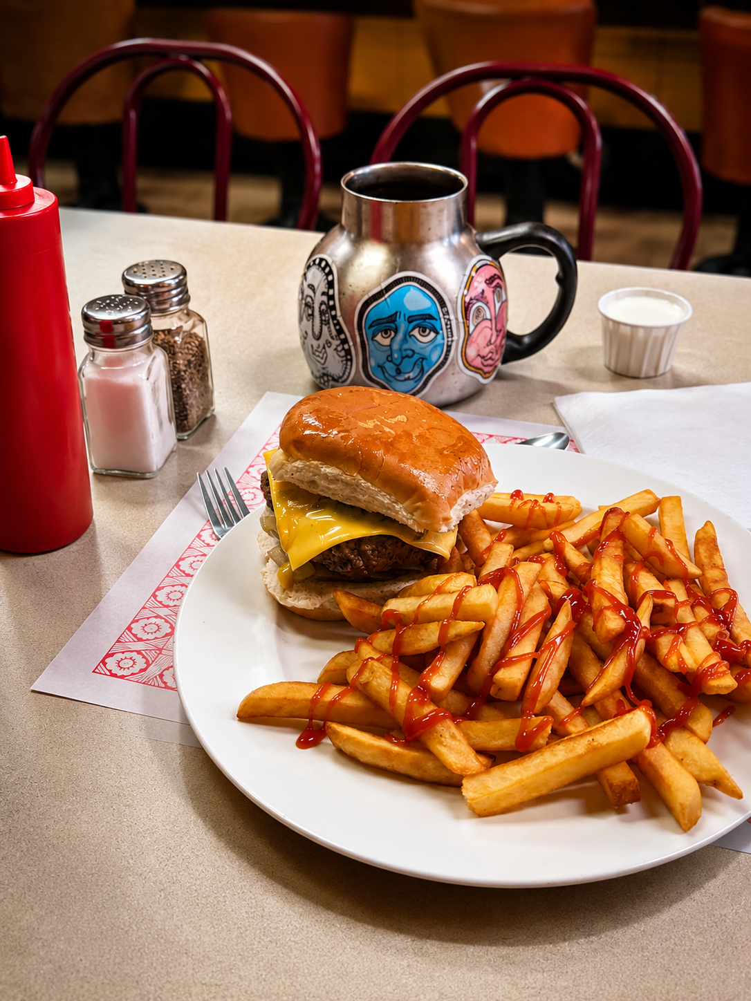 Cheeseburger and fries on a diner table