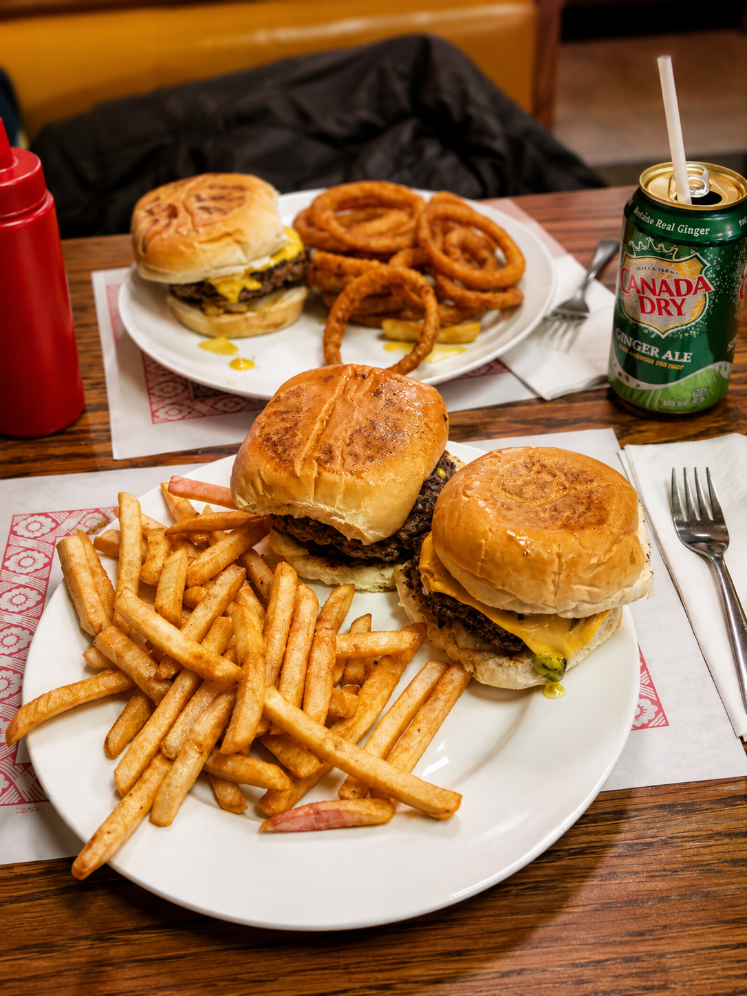Burgers, fries and onion rings shared across a diner table